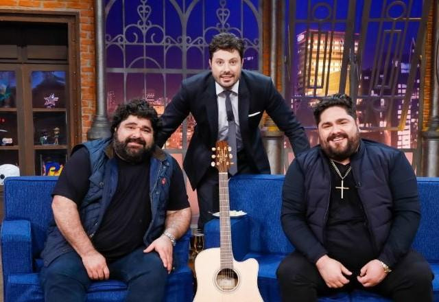 Danilo Gentili e César Menotti & Fabiano posam para foto no palco.