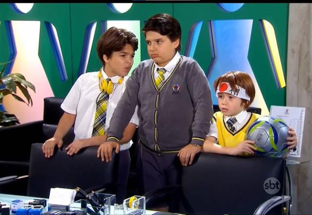 Paulo, Jaime e Kokimoto segurando uma bola de futebol na sala da direção