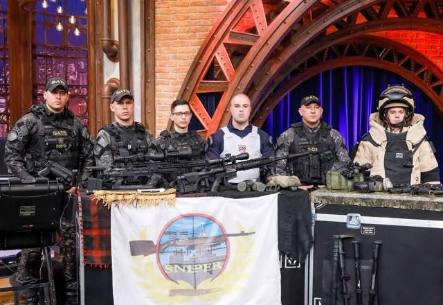 Capitão Pavão, Soldado Gustavo e os convidados do GATE posam para foto.