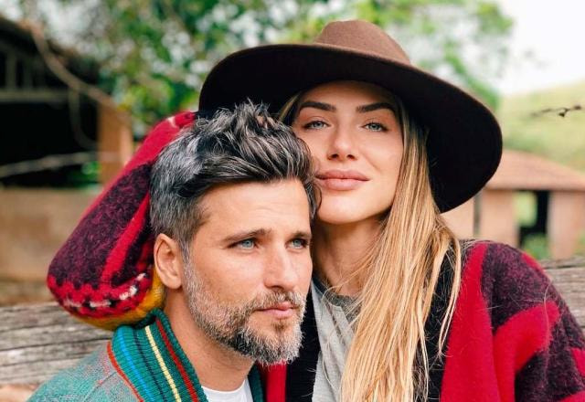 Giovanna Ewbank e Bruno Gagliasso estão abraçados em uma praia