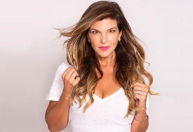 Cristiana Oliveira posa para foto segurando os cabelos