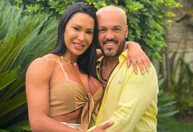 Gracyanne Barbosa e Belo posam abraçados em jardim sorrindo