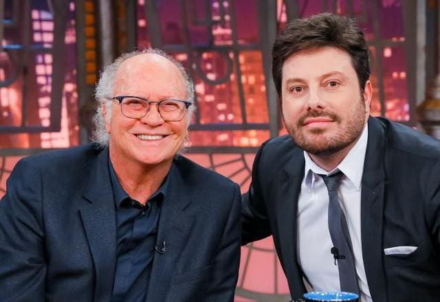 Paulo Roberto Falcão e Danilo Gentili posam juntos para foto.