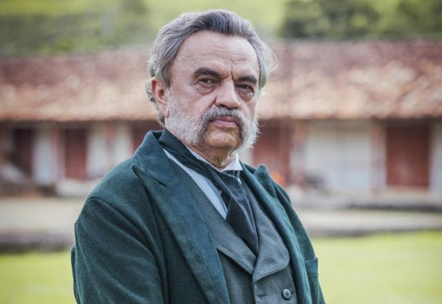 José Dumont posa nos bastidores de novela olhando sério para a câmera