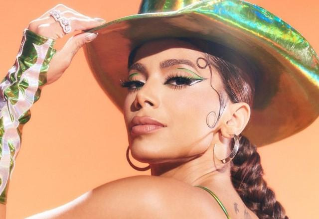 Anitta posa de lado com um chapéu de cowboy