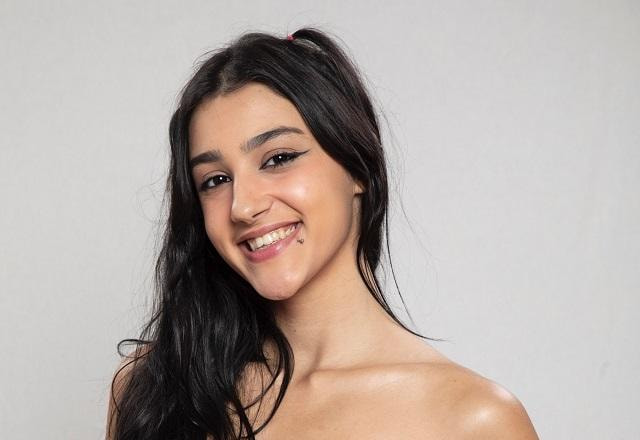 Bia Miranda sorri e posa em fundo branco