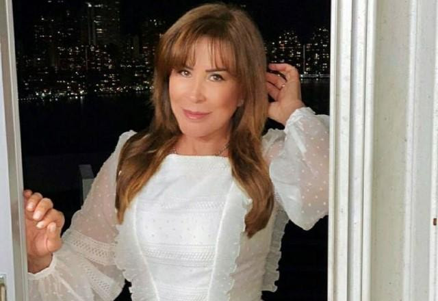 Zilu posa com vestido branco em frente a porta