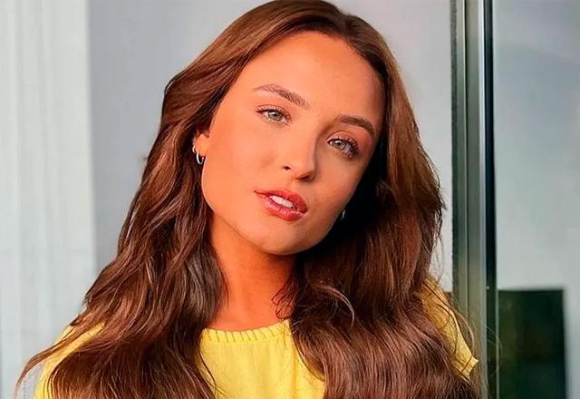 Larissa Manoela posa usando blusa amarela e olhando fixo para a câmera