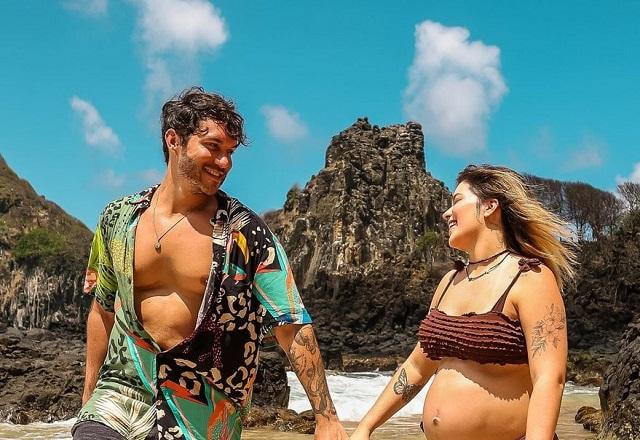 Eliezer e Viih Tube posam de mãos dadas e olhando um para o outro na praia