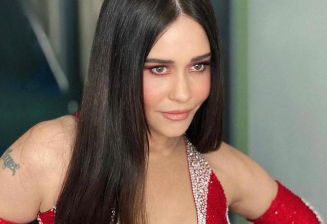 Alessandra Negrini posa para foto usando macacão vermelho decotado