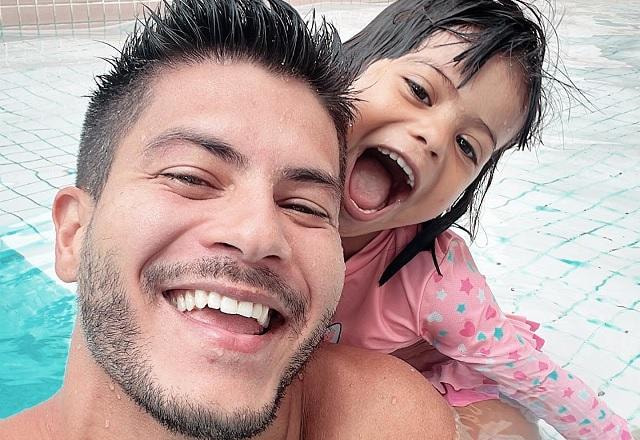 Arthur Aguiar e Sophia posam sorrindo dentro da piscina