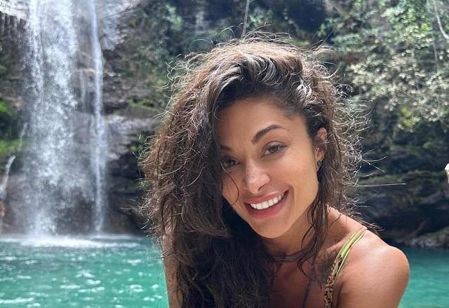 Aline Campos posa sorrindo em cachoeira