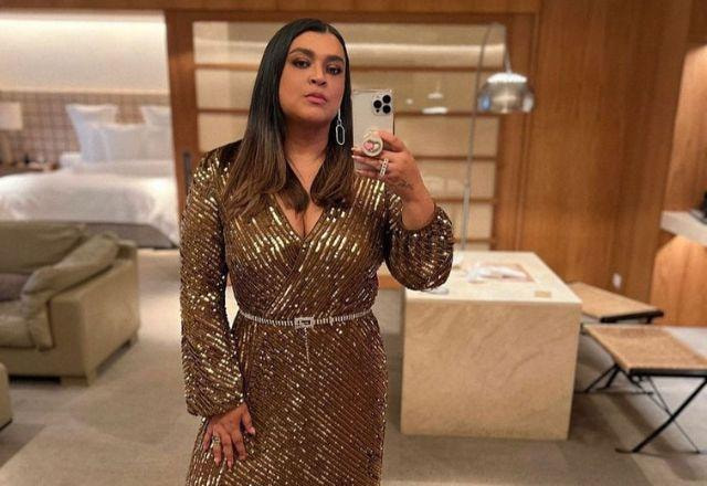 Preta Gil tira selfie em frente ao espelho, fazendo cara de séria e usando vestido de dourado