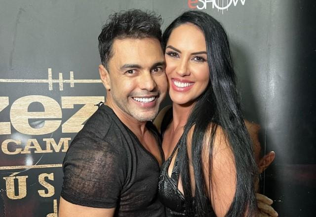 Zezé Di Camargo e Graciele posam abraçados e sorrindo nos bastidores de show