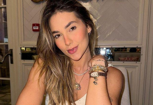 Virginia Fonseca posa sorrindo para a câmera, usando roupa branca e com a mão no pescoço