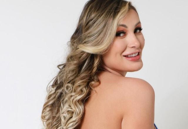 Andressa Urach posa de biquíni, de costas e sorrindo