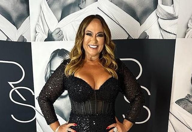 Nadine Gonçalves posa usando roupa preta, sorrindo e com as mãos na cintura