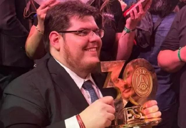 Casimiro segurando troféu de Lionel Messi durante o leilão de Neymar Jr.