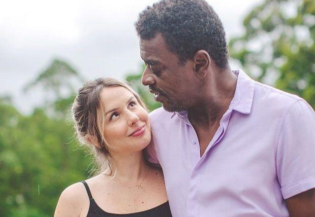 Seu Jorge e esposa grávida posam para foto em paisagem de floresta