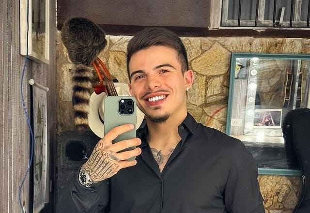 Thomaz Costa tira selfie no espelho sorrindo e usando roupa social