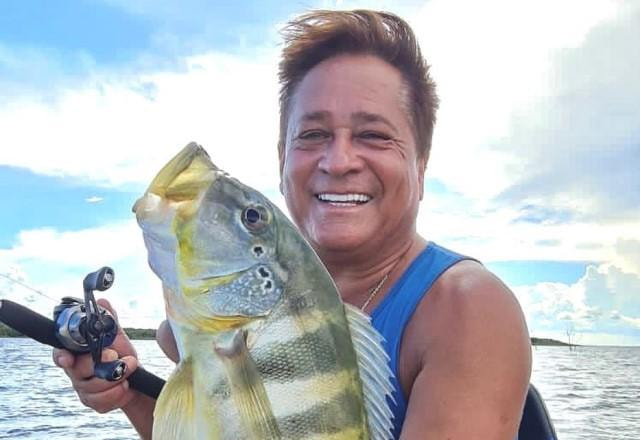 Leonardo posa sorrindo e segurando um peixe recém-pescado