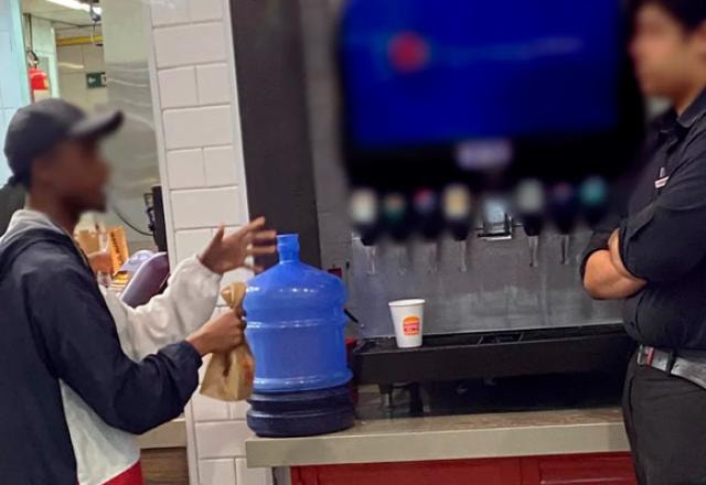 Imagem do homem com o galão de 20 litros no fast food