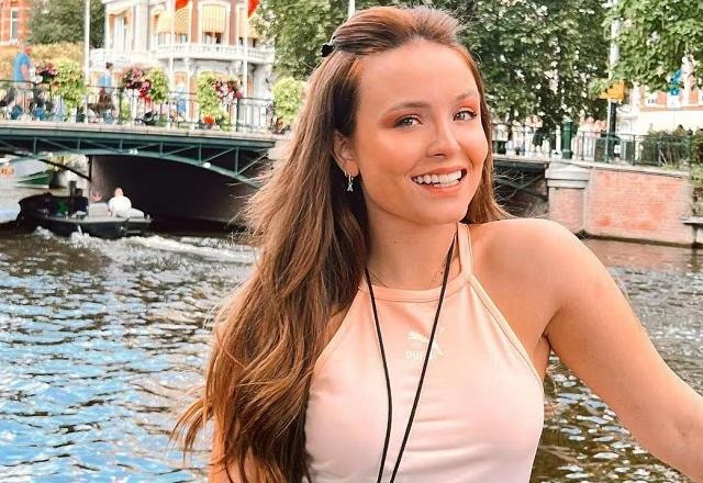 Larissa Manoela posa sorrindo em frente a um rio