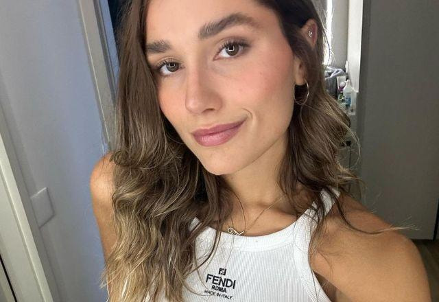 Sasha Meneghel posa sorrindo e usando regata branca