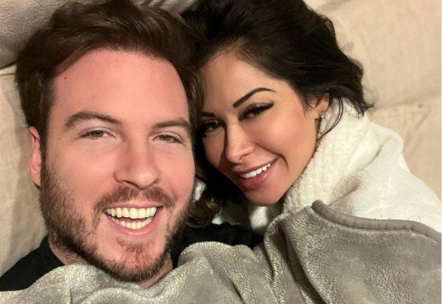 Maíra Cardi e Thiago Nigro tiram selfie deitados no sofá e sorrindo