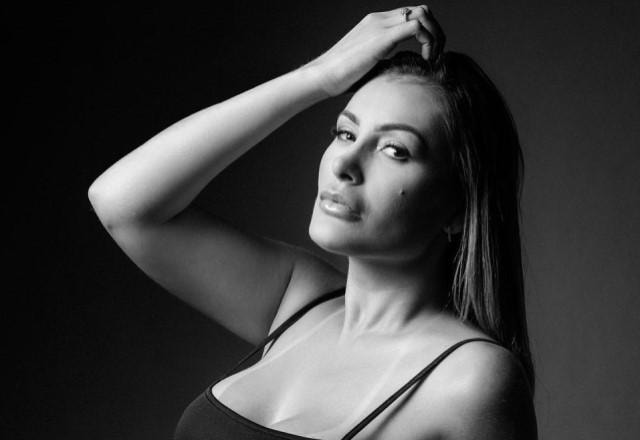 Andressa Urach posa fazendo carão com a mão na cabeça em foto em preto e branco