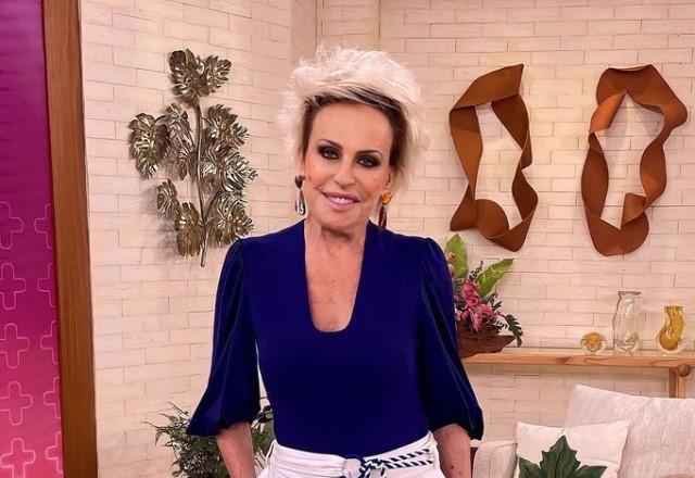 Ana Maria Braga posa sorrindo no cenário de seu programa