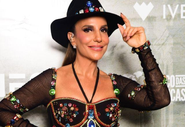 Ivete Sangalo posa sorrindo  e segurando chapéu