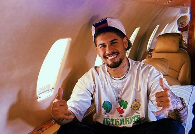 Zé Felipe posa sorrindo e fazendo jóia com a mão dentro do avião