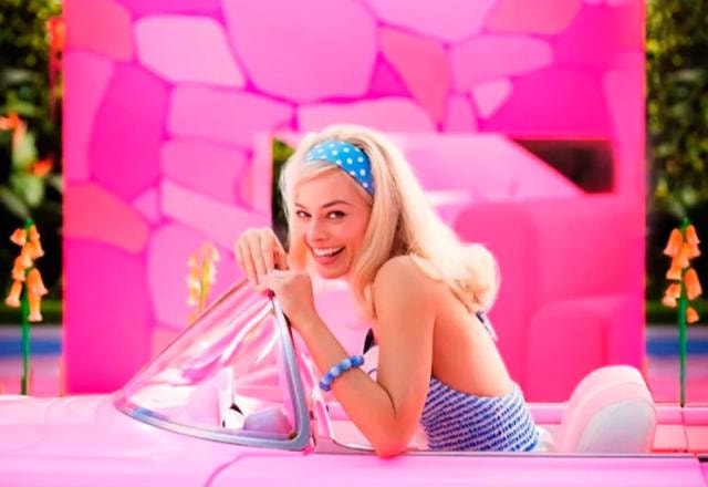 Margot Robbie, como Barbie, posa dentro de carro cor de rosa