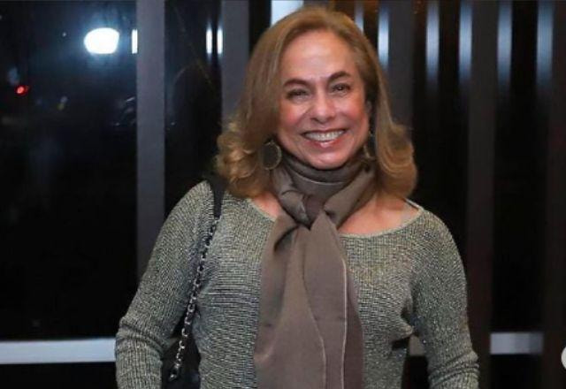 Cissa Guimarães posa sorrindo em frente a janela de vidro