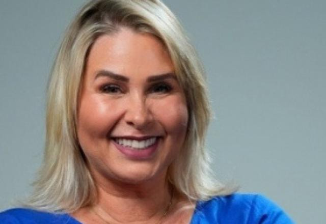 A ex-paquita Andréa Sorvetão sorri usando blusa azul