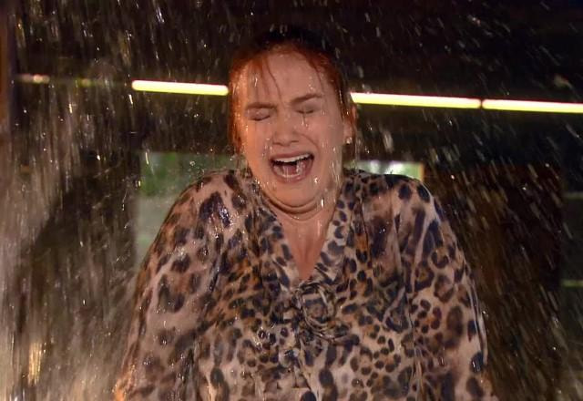 Regina recebendo um balde de água na cabeça e gritando