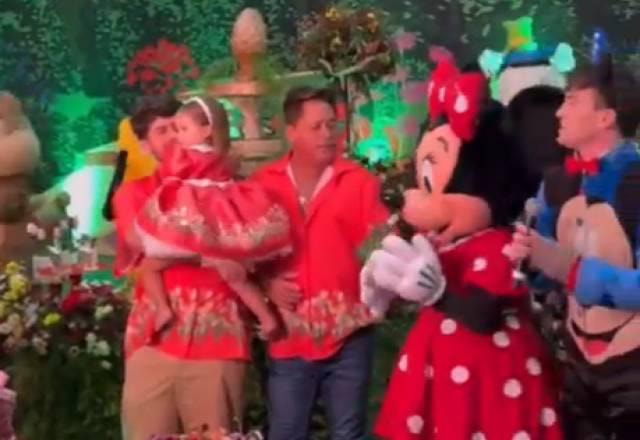 Leonardo oferecendo bebida para a personagem Minnie no aniversário da neta