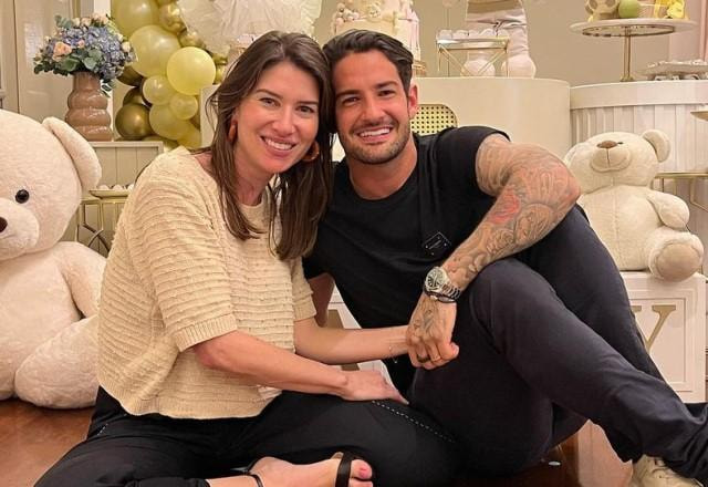 Rebeca Abravanel e Alexandre Pato posam sorrindo sentados no chão