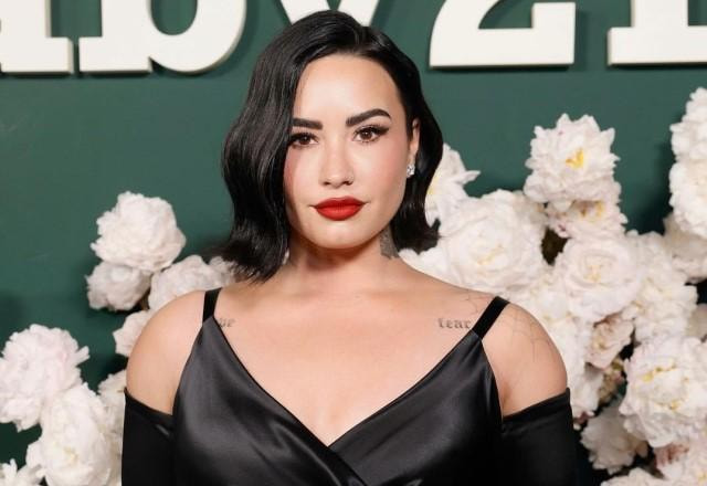 Demi Lovato posa olhando para a câmera em tapete vermelho de evento