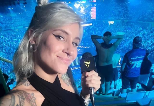 mari ayrez com microfone na mão e estádio lotado atrás