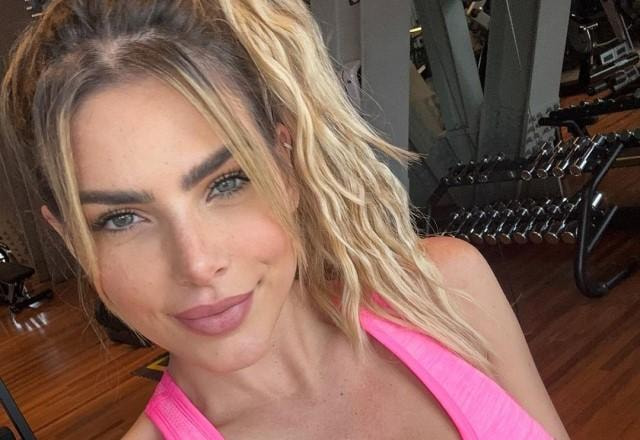 Erika Schneider tira selfie sorrindo e usando top rosa