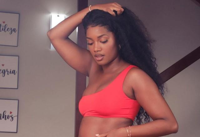 IZA posa grávida e segurando a barriga