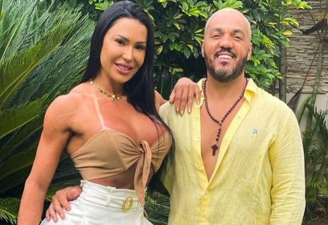 Belo e Gracyanne Barbosa posam em um jardim abraçados e sorrindo