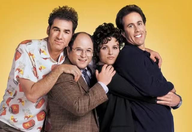Personagens de Seinfeld posam abraçados e sorrindo