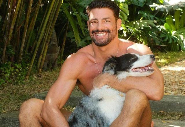 Cauã Reymond posa sorrindo e abraçado com sua cachorra, Shakira