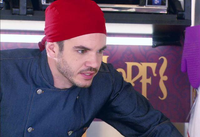 Vitor com roupa de chef, touca vermelha e expressão de raiva