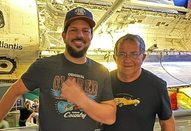 Sorocaba ao lado de seu pai José Carlos Assis, Sorocaba vestindo camisa preta e boné azul e seu pai vestindo camisa preta