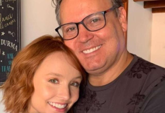 Uma foto em close de Larissa Manoela e seu pai Gilberto Elias Santos, se abraçando e olhando para frente