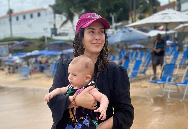 Foto de Fernanda Paes Leme segurando sua filha Pilar em uma praia